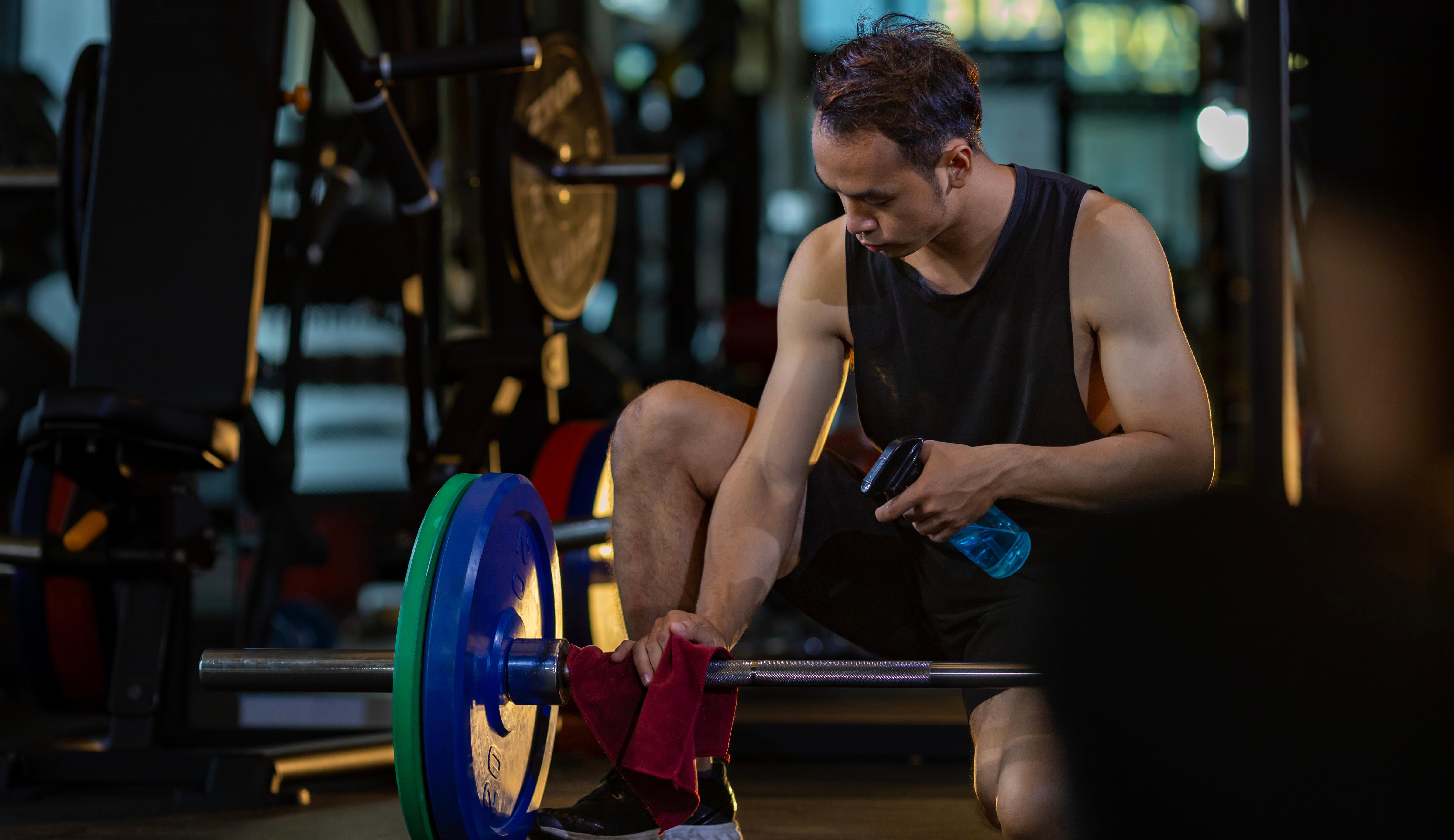 Hombre limpiando herramientas del gimnasio