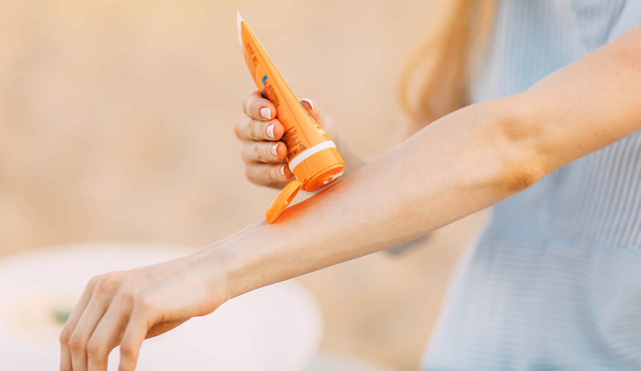 Persona aplicándose protección solar