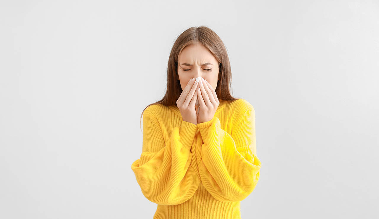Mujer sonándose los mocos