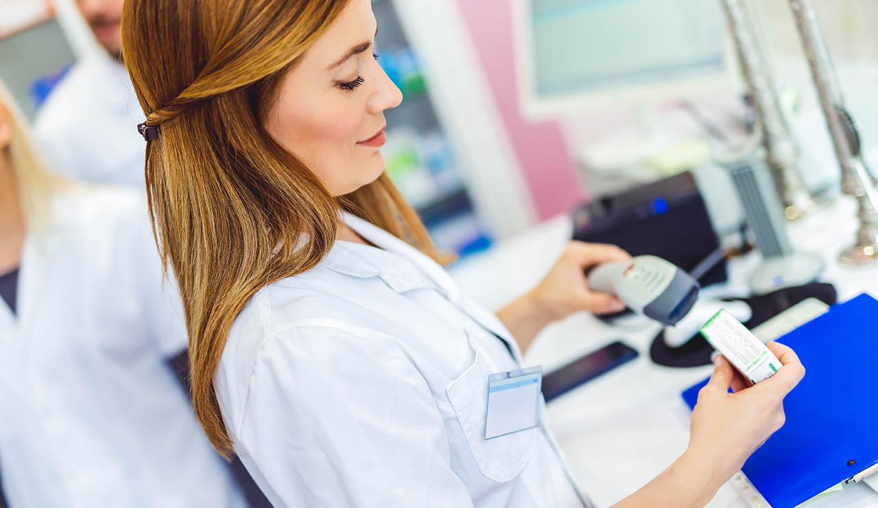 Farmacéutica pasando un medicamento por el escáner