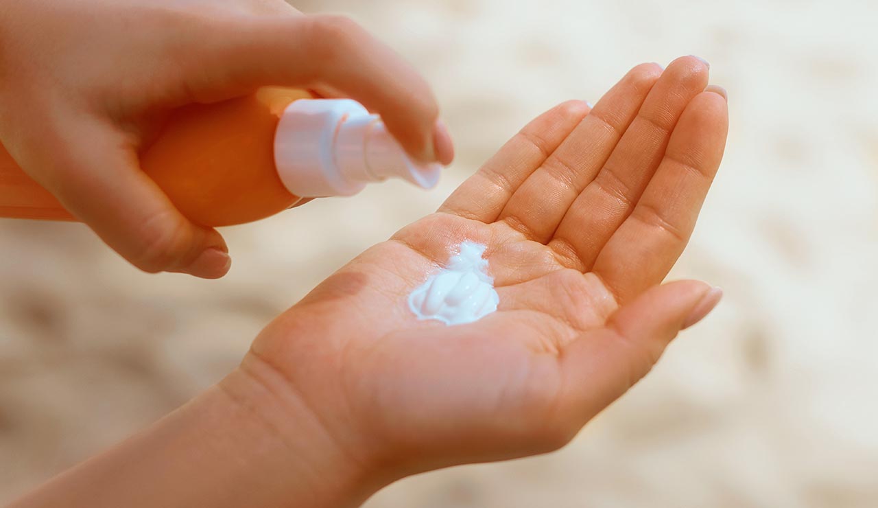 Crema solar en la mano
