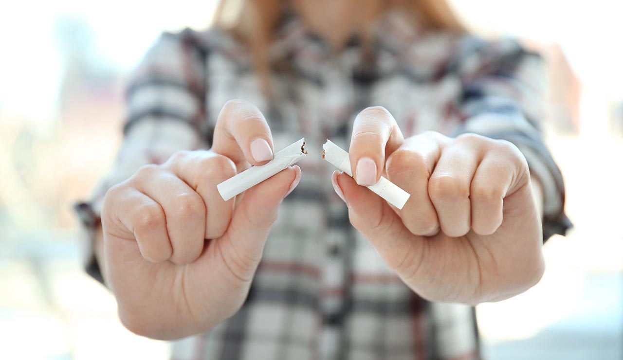 Mujer rompiendo un cigarro
