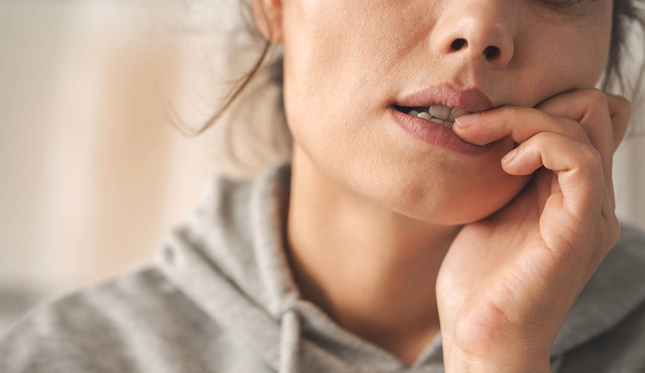 Mujer mordiéndose las uñas