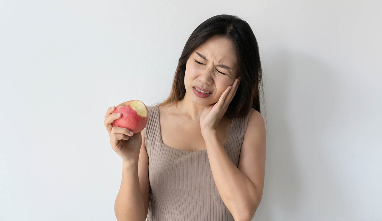 Mujer con aftas comiendo una manzana