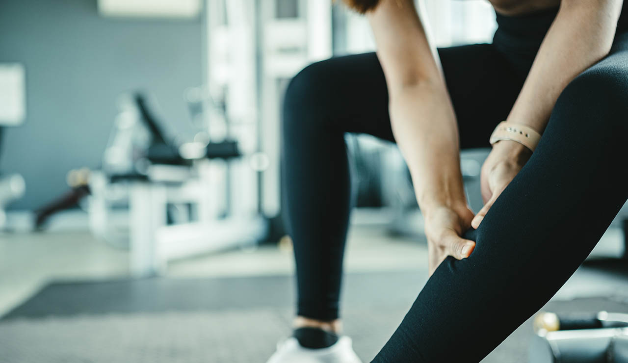 Mujer en el gimnasio con agujetas