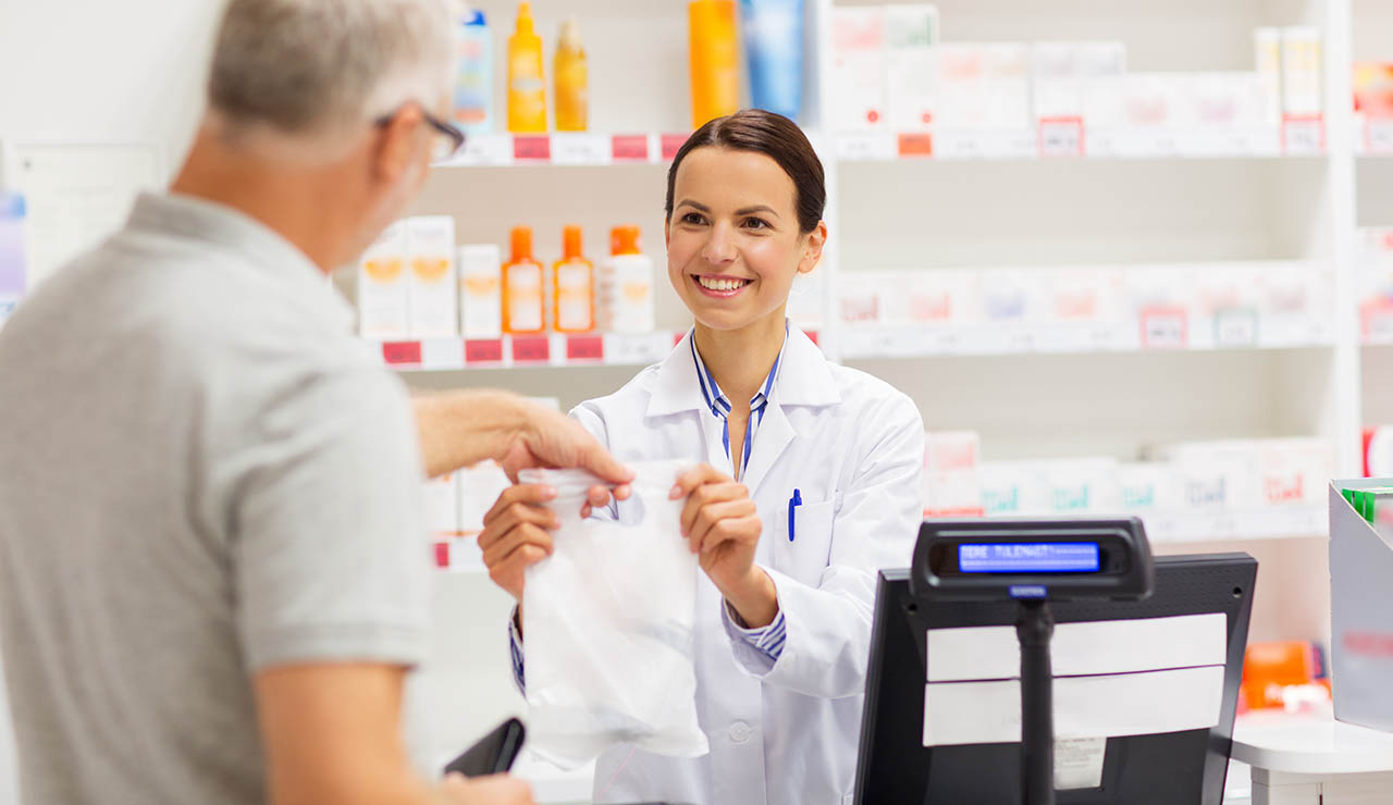 Farmacéutica dando una bolsa con un regalo