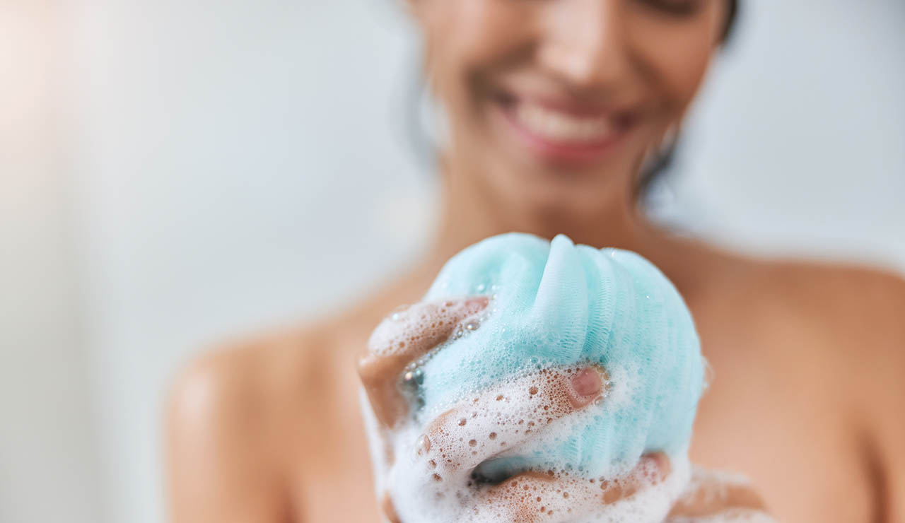 Mujer con una esponja en la ducha