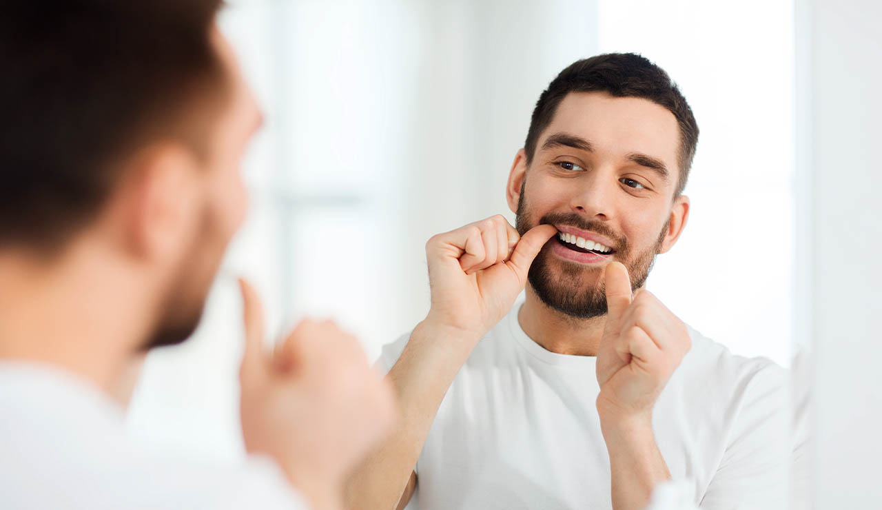 Hombre usando hilo dental